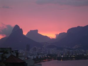 Pink sky, buildings surrounded by mountains - sunset over Lagoa