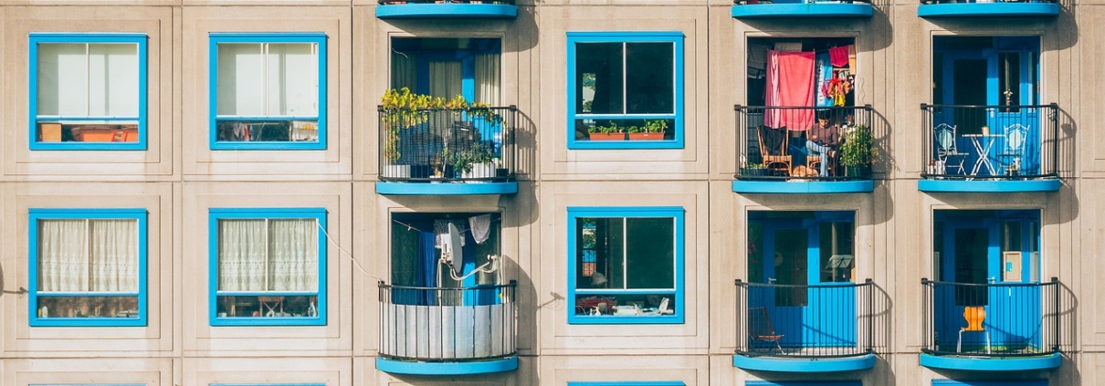 Apartment building with blue windows and small balconies