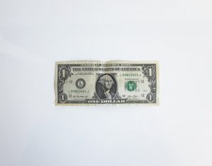 Saving dollars such as this dollar bill is not done through hiring low-cost international movers.